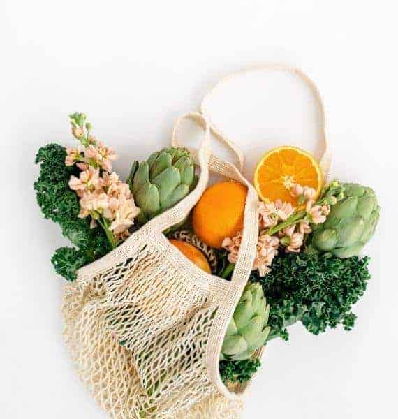 Grocery bag with fruits and veggies, following a vegan lifestyle.