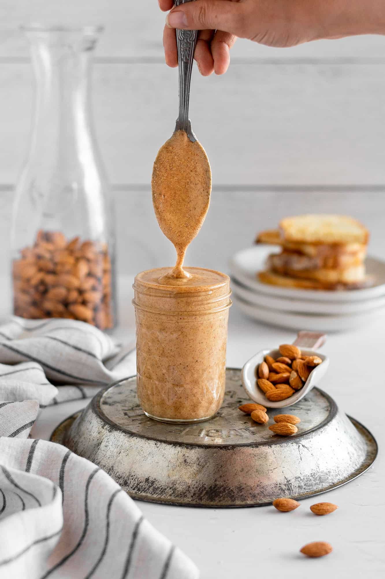 homemade almond butter being scooped with a spoon. 