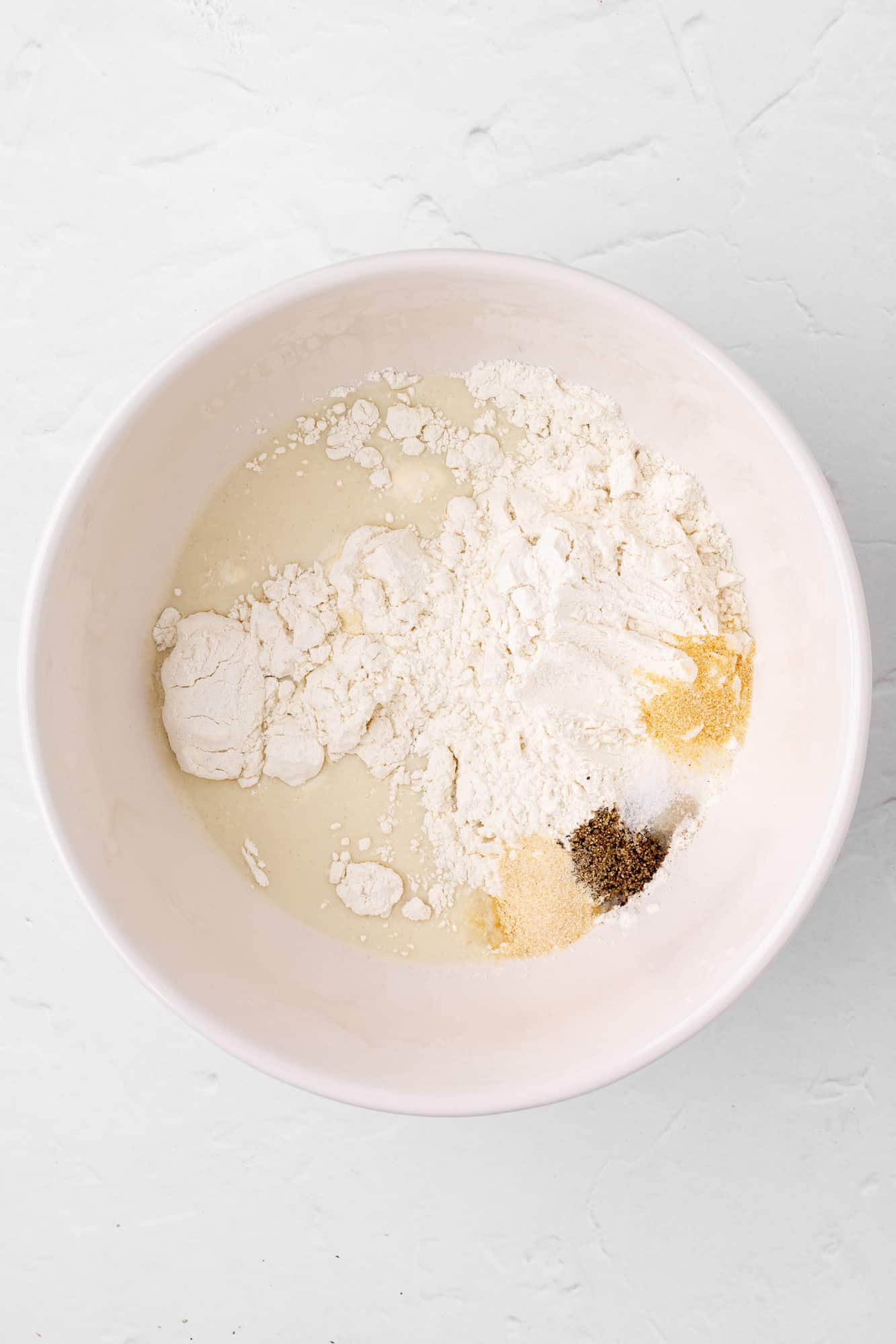 batter ingredients in a bowl - milk, flour, and spices