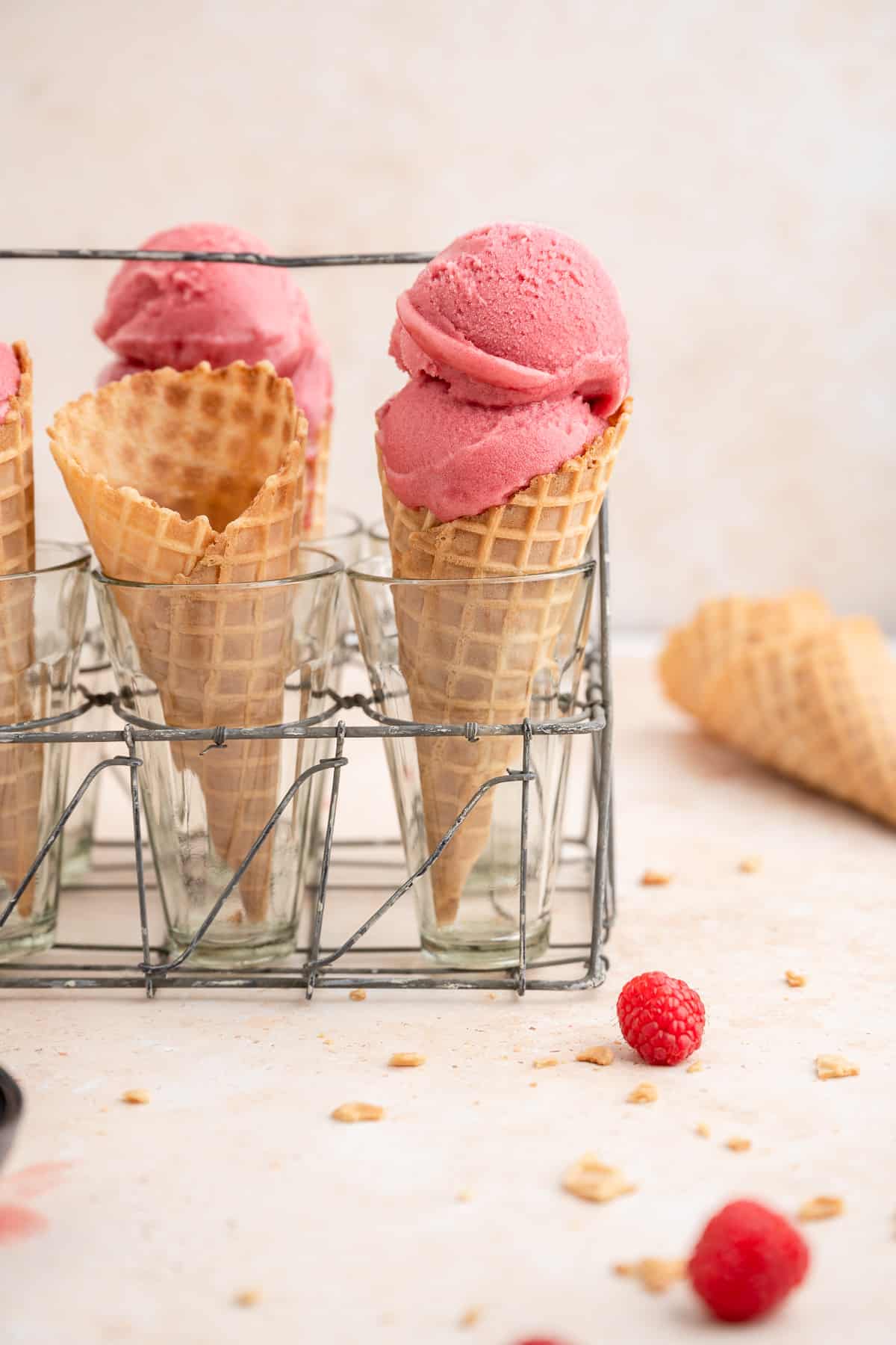 two raspberry sorbet scoops on a cone. 