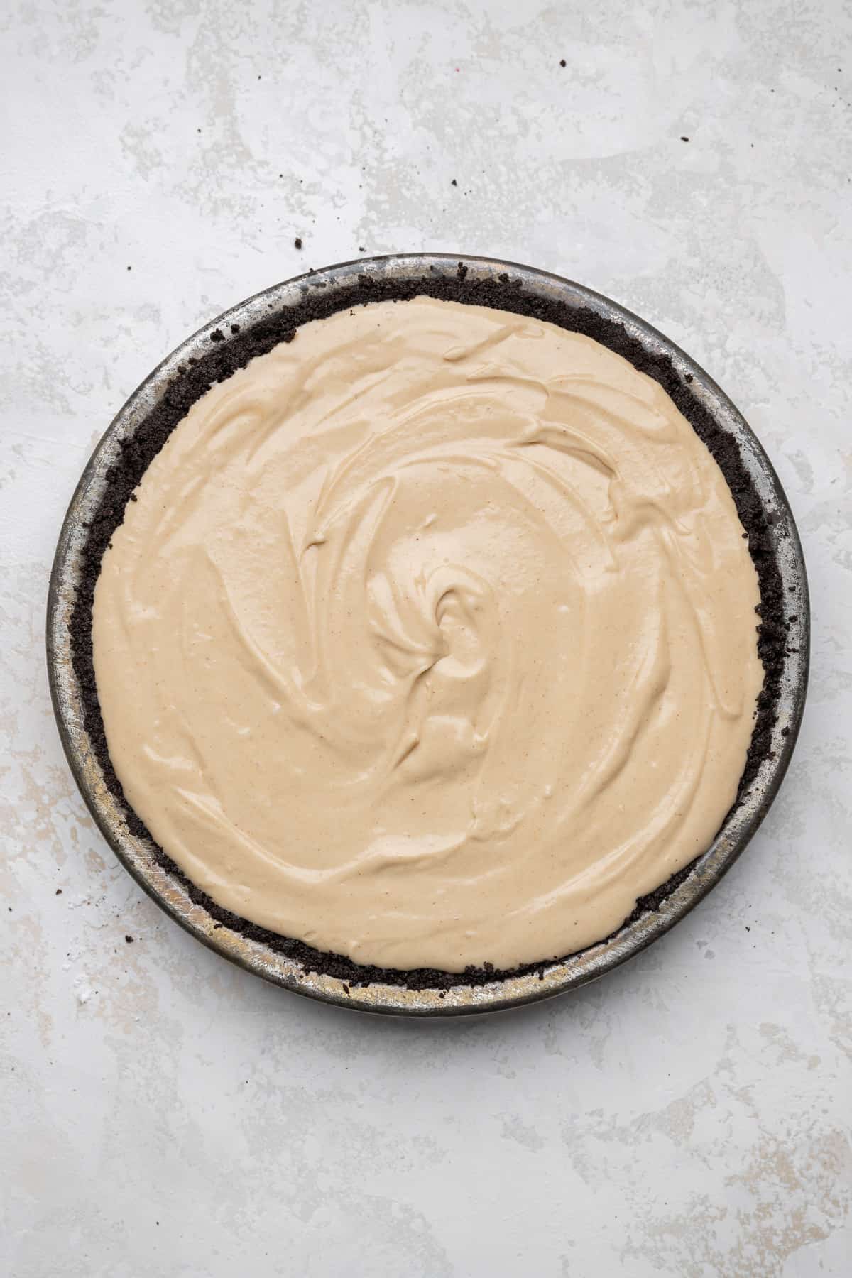 peanut butter filling in a pie pan with an oreo crust