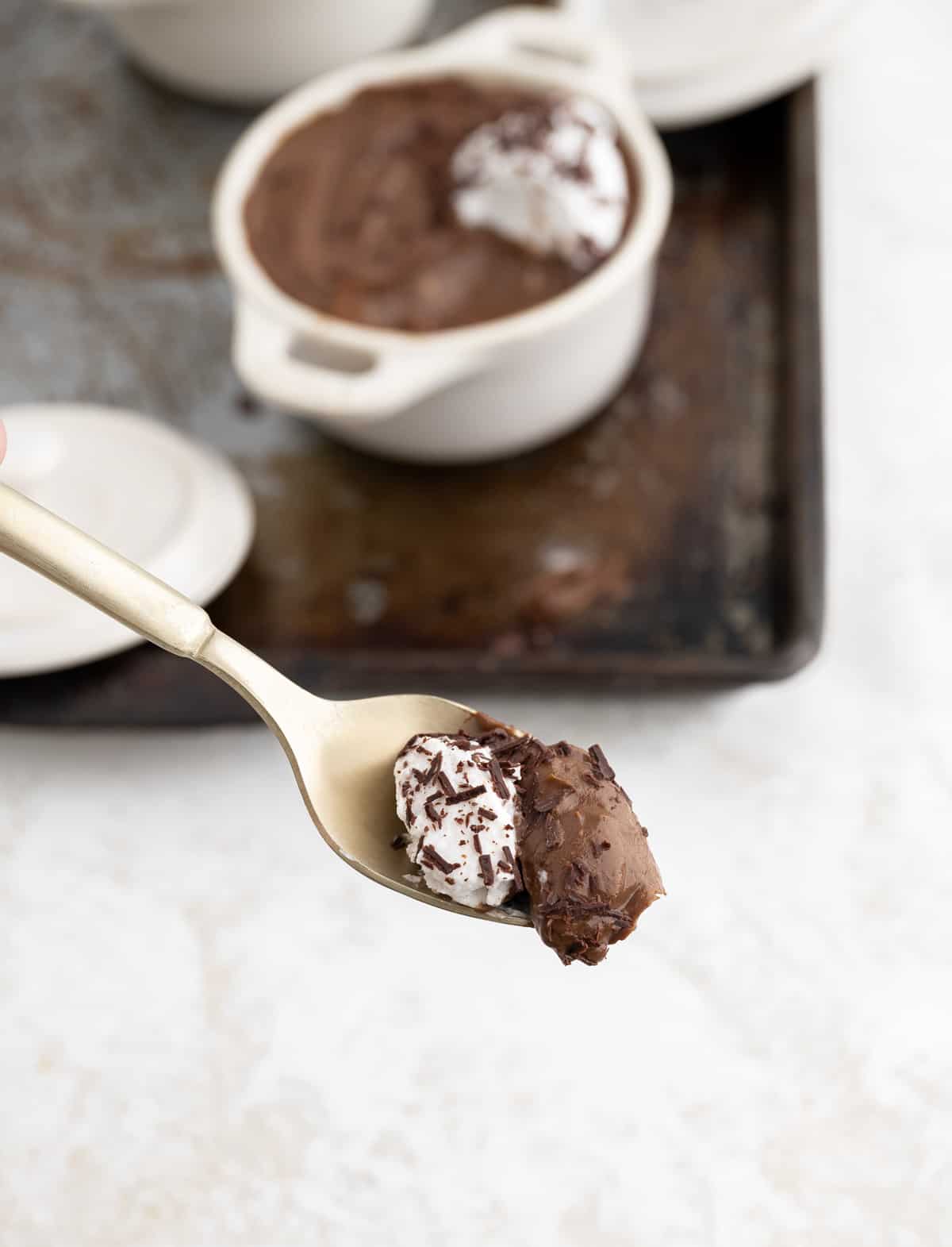 chocolate avocado mousse and coconut creme on a gold spoon