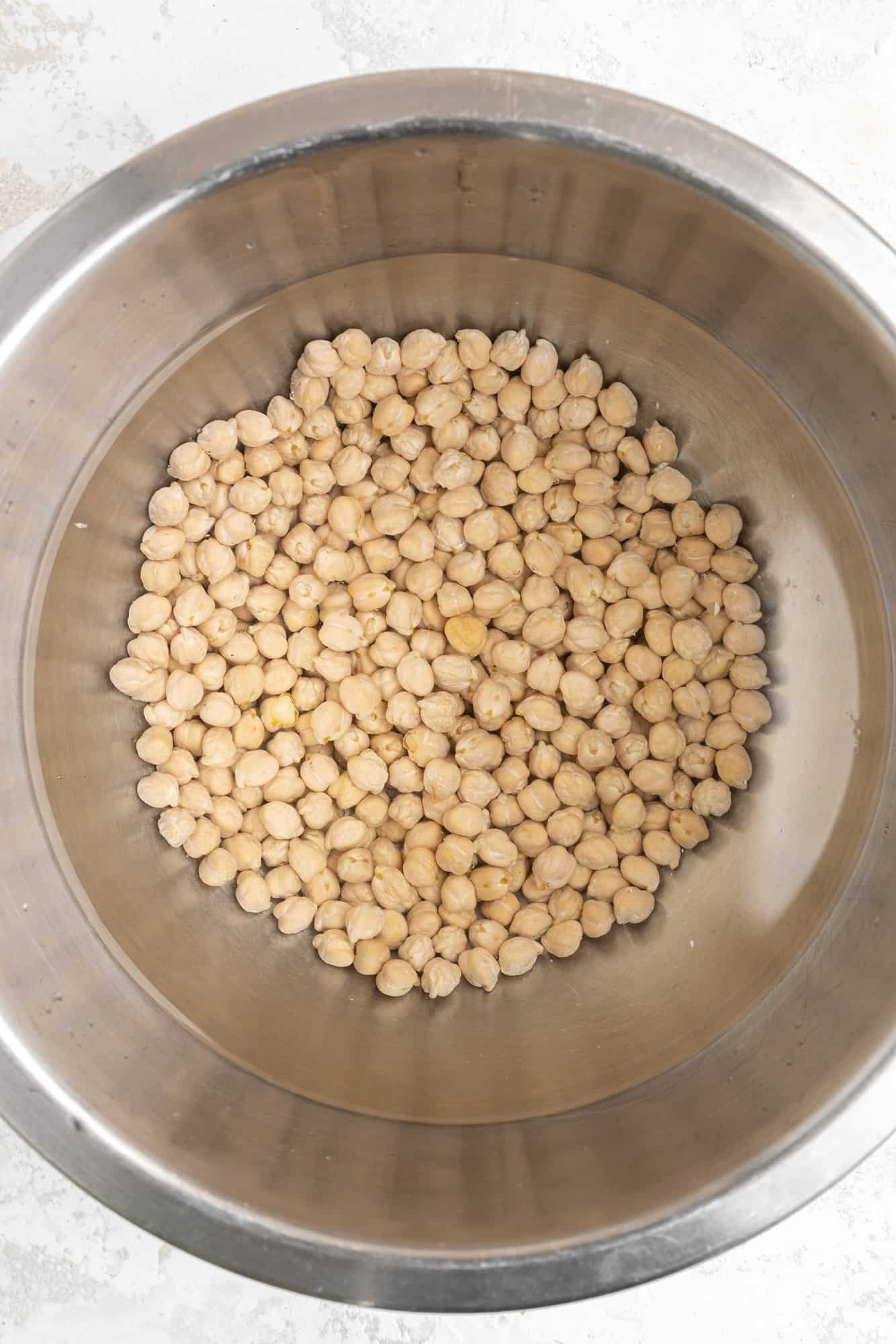 Dried chickpeas in a bowl with water