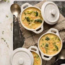 3 white ramekins filled with broccoli cheddar soup
