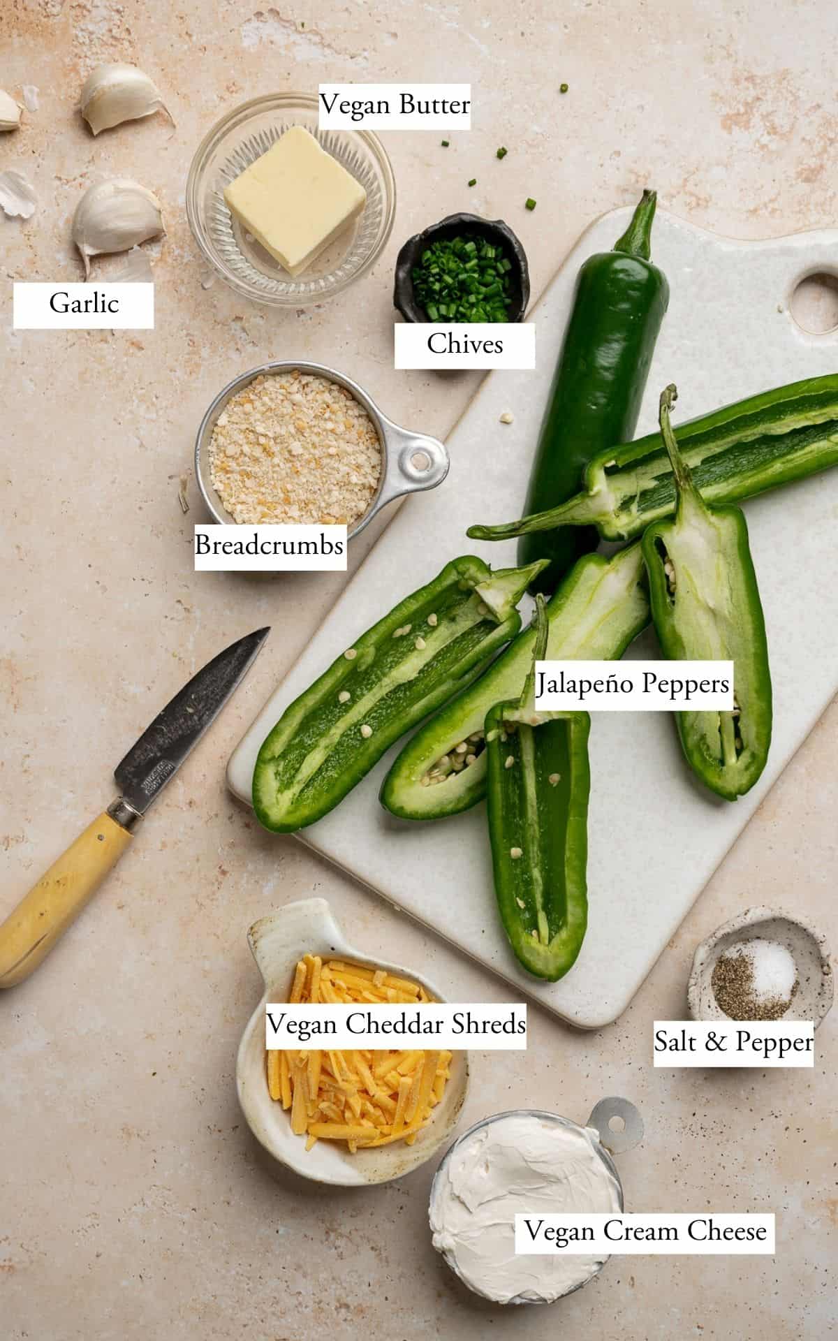 ingredients for jalapeño poppers: jalapenos, cream cheese, cheddar cheese, chives, bread crumbs, salt & pepper.