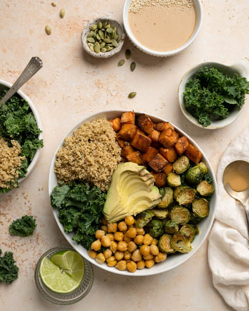 buddha bowl with sweet potatoes, chickpeas, brussel sprouts, kale, quinoa, and avocado