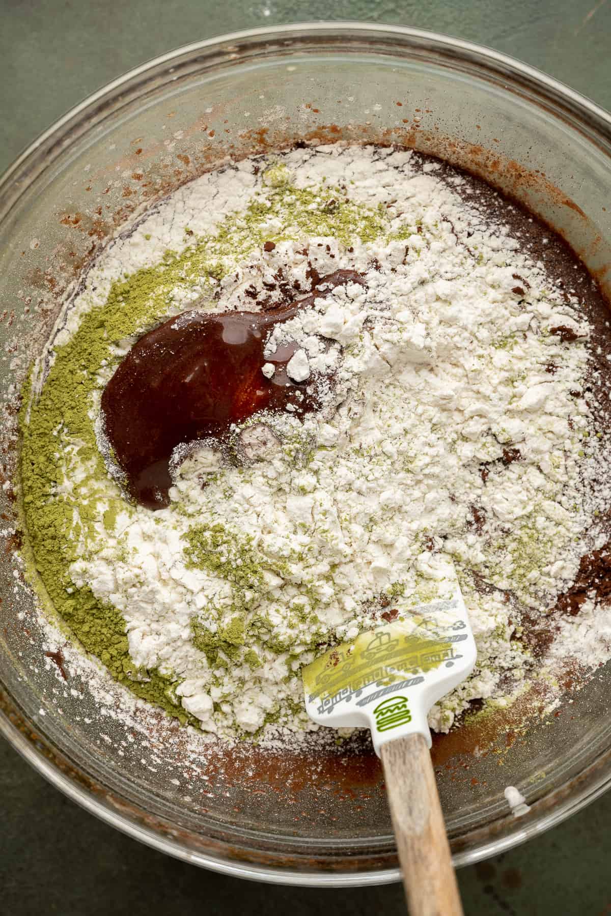 flour, matcha powder, and cocoa powder added to the wet ingredients of brownie batter.