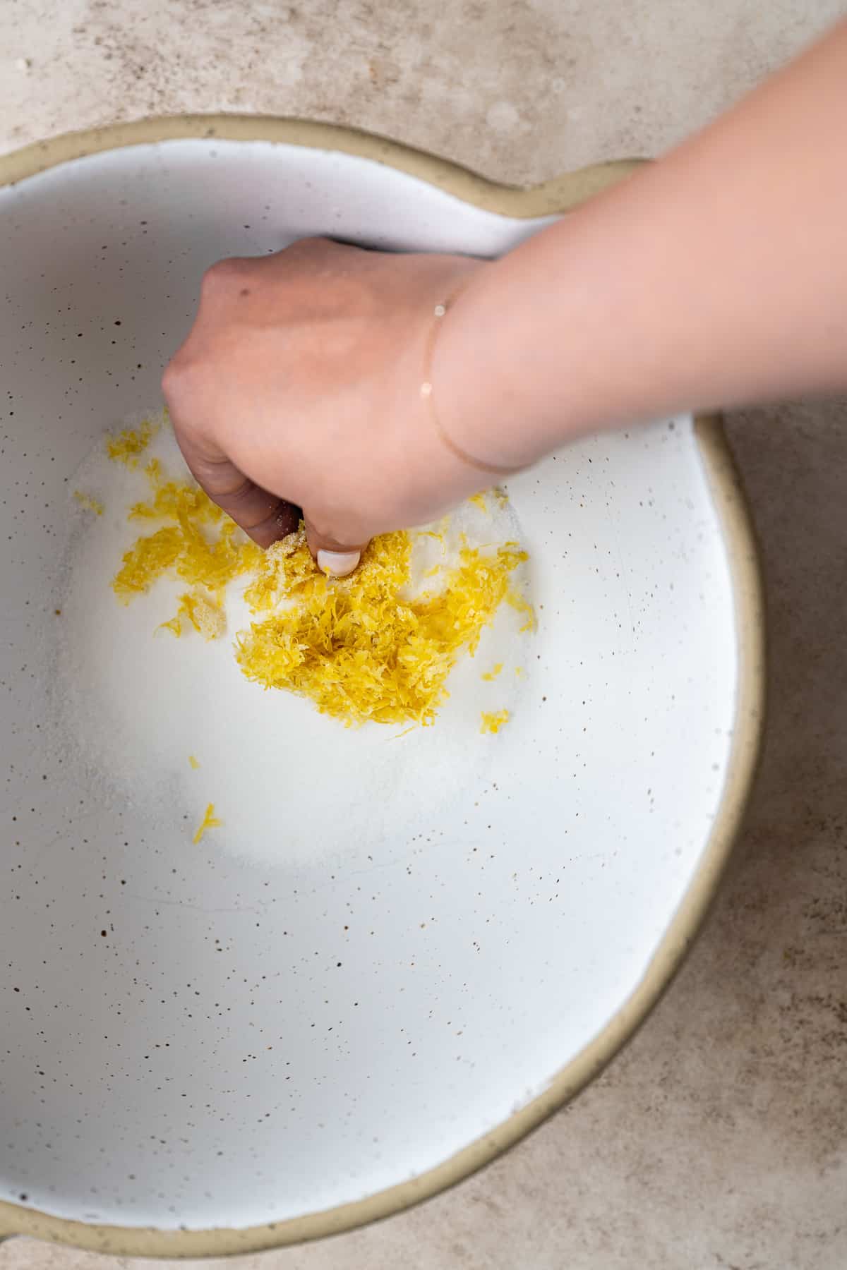 lemon zest being mixed into sugar.