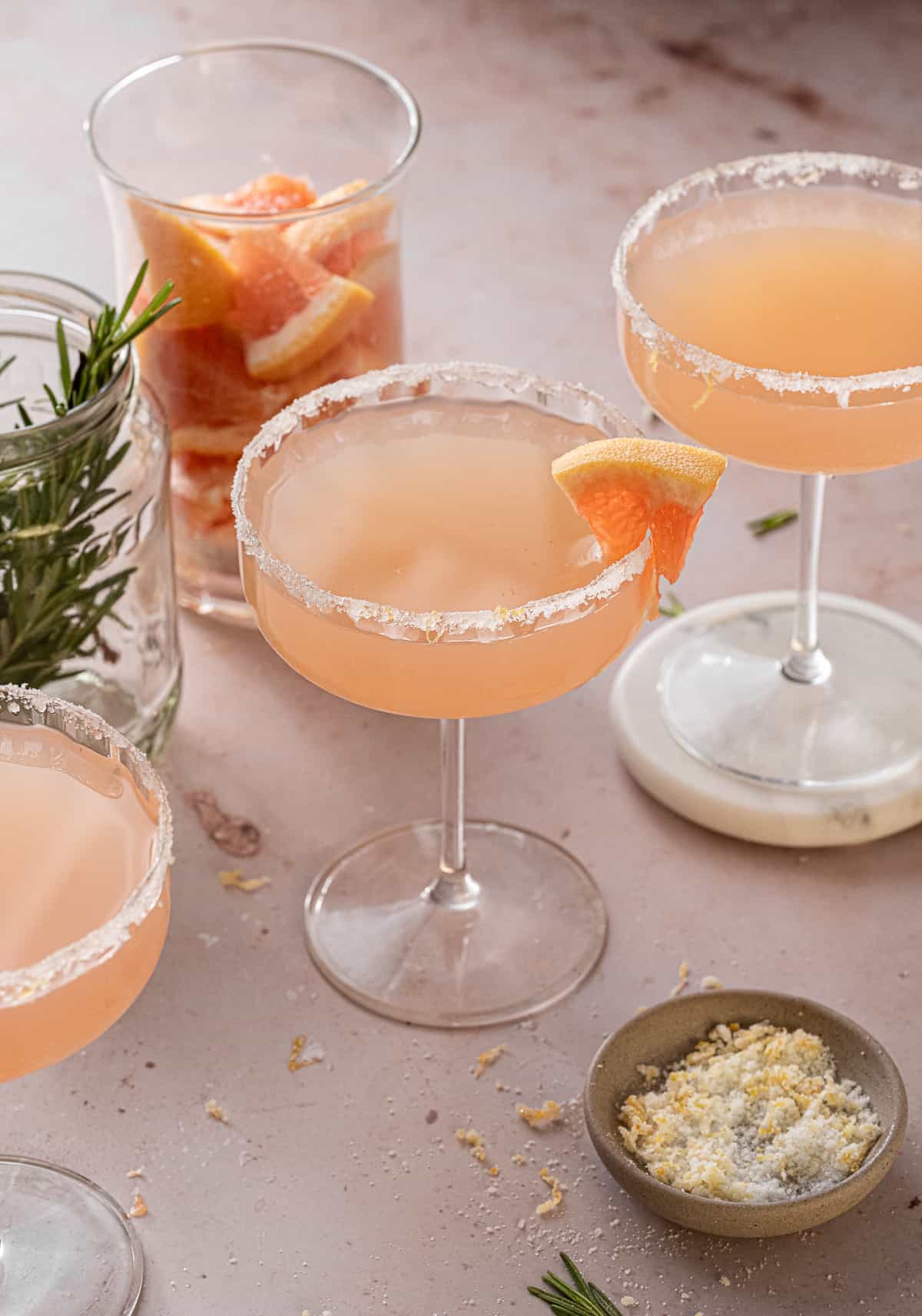 grapefruit gin and prosecco cocktail in coupe glasses with a sugar rim and grapefruit garnish.