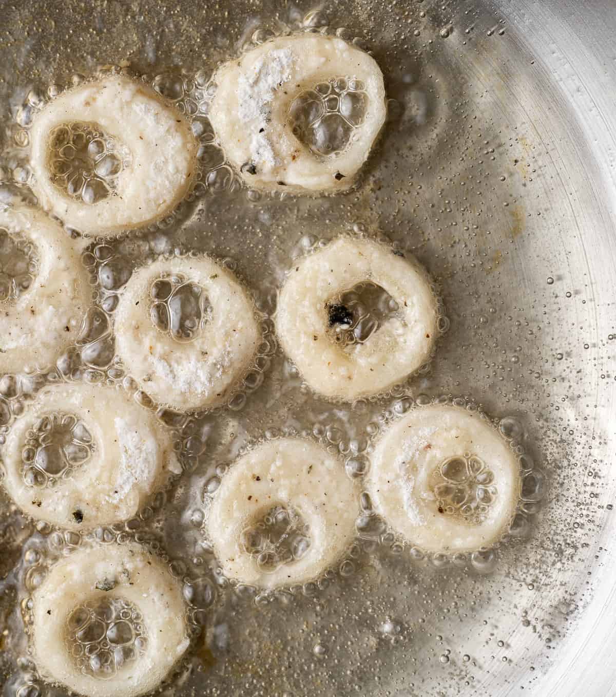 uncooked battered calamari rings in hot oil.