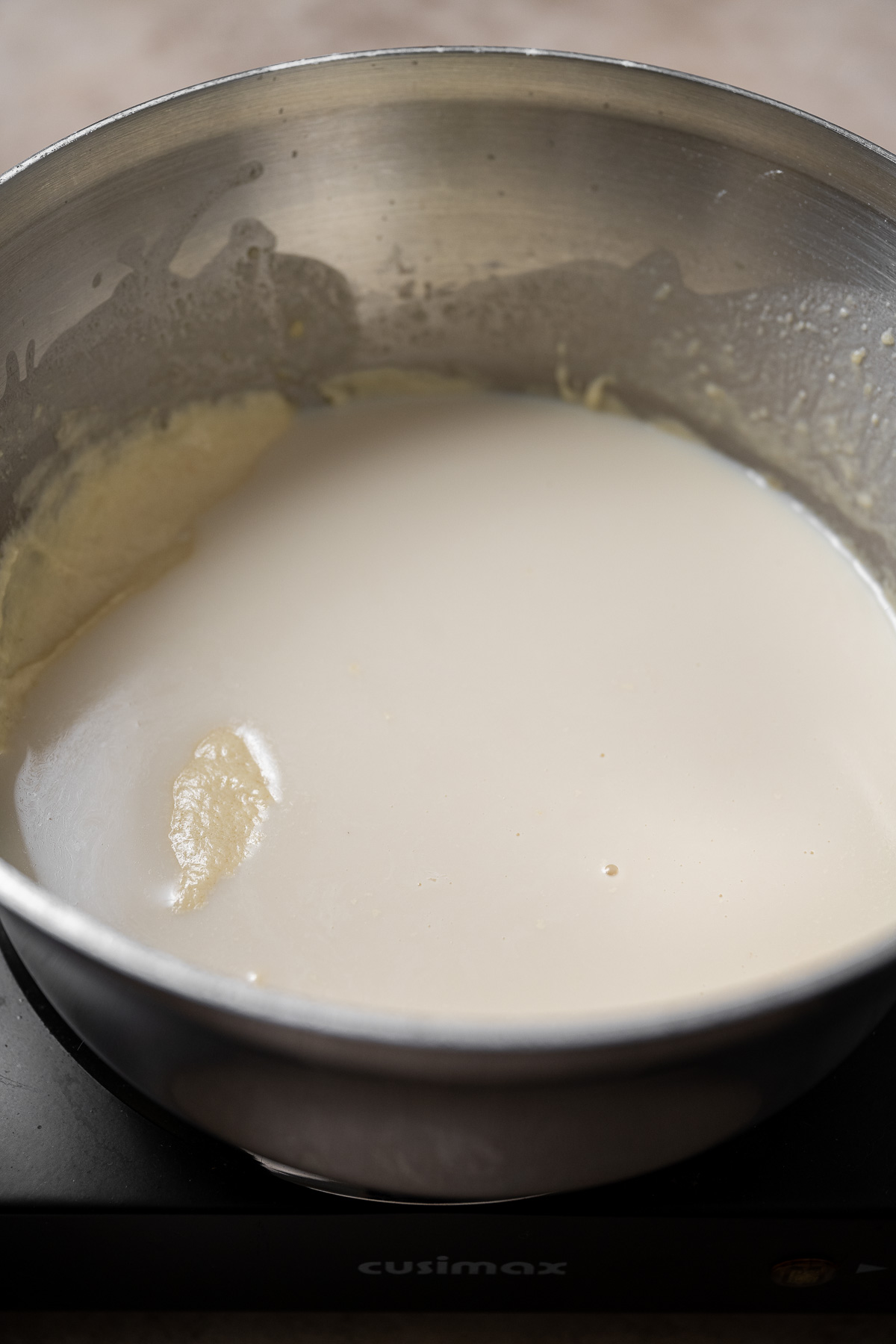 milk being added to bechamel.