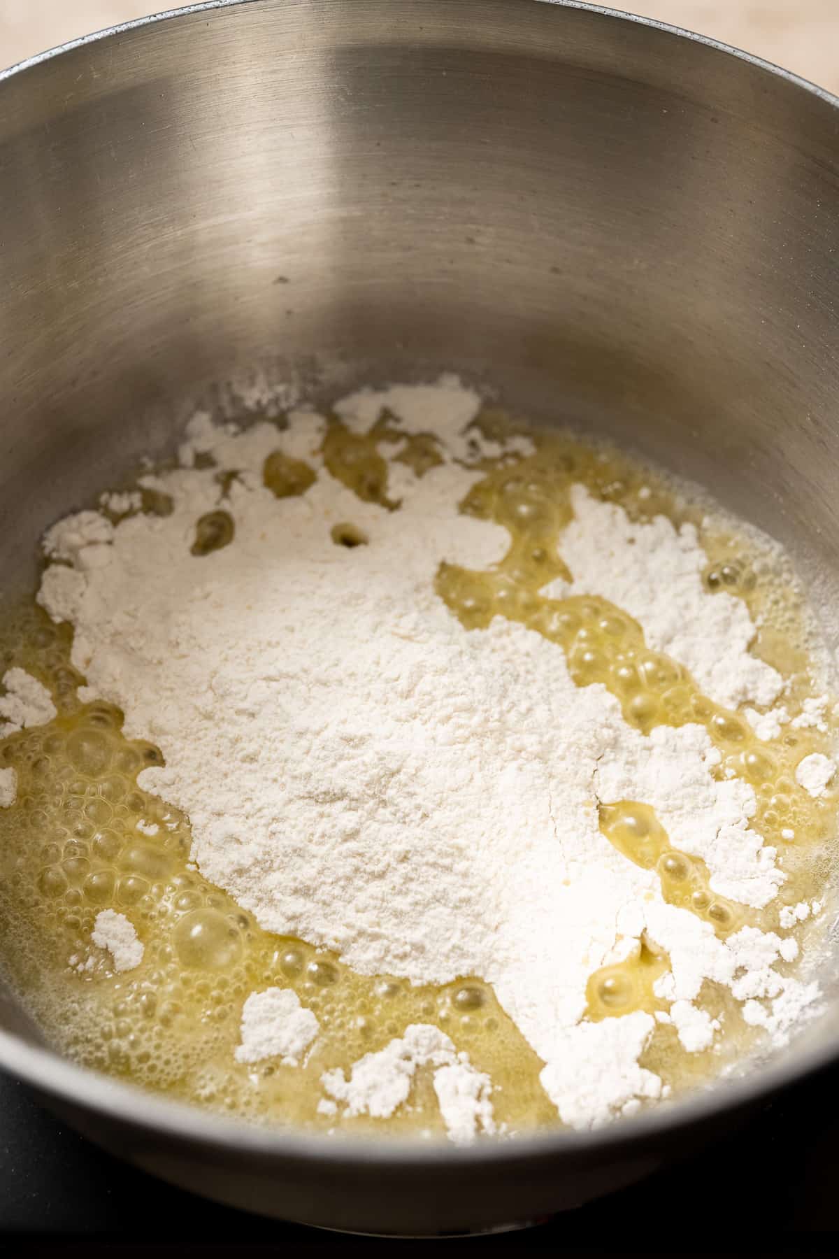 All-purpose flour being added to melted butter.