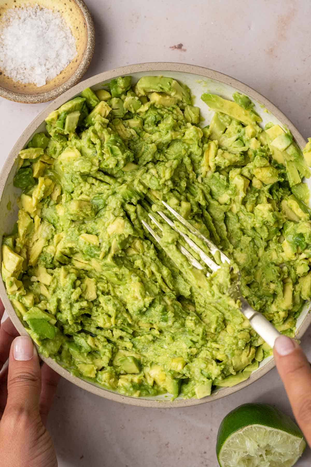4 ingredient guacamole being mashed with a fork.