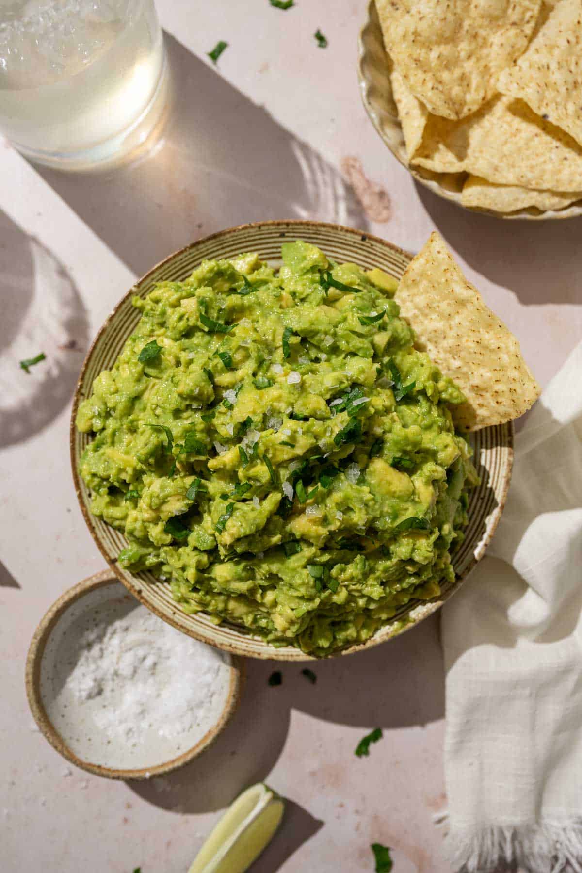 guacamole in a bowl topped with sea salt and cilantro.