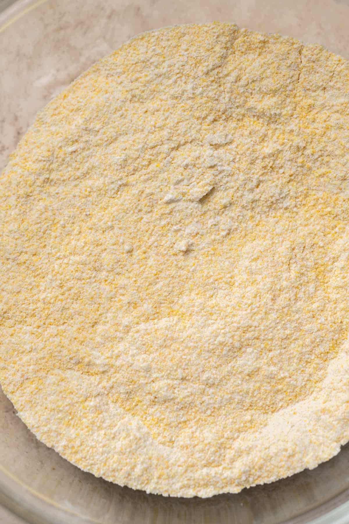 polenta, flour, baking powder and salt mixed in a bowl.