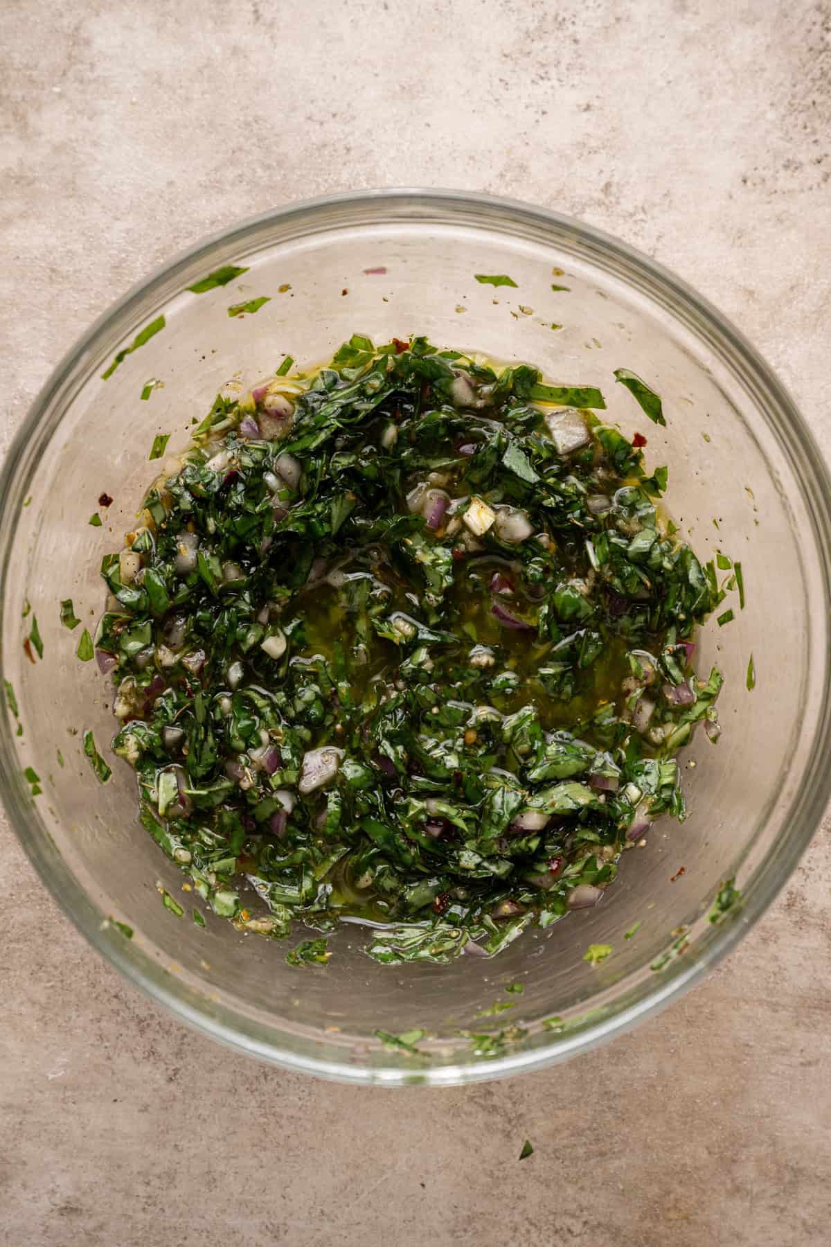 basil chimichurri whisked together in a mixing bowl.