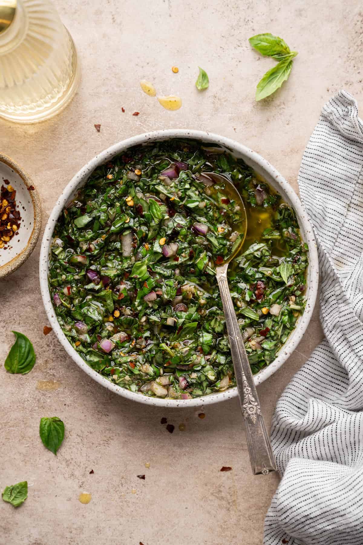 basil chimichurri in a bowl with a spoon in it.